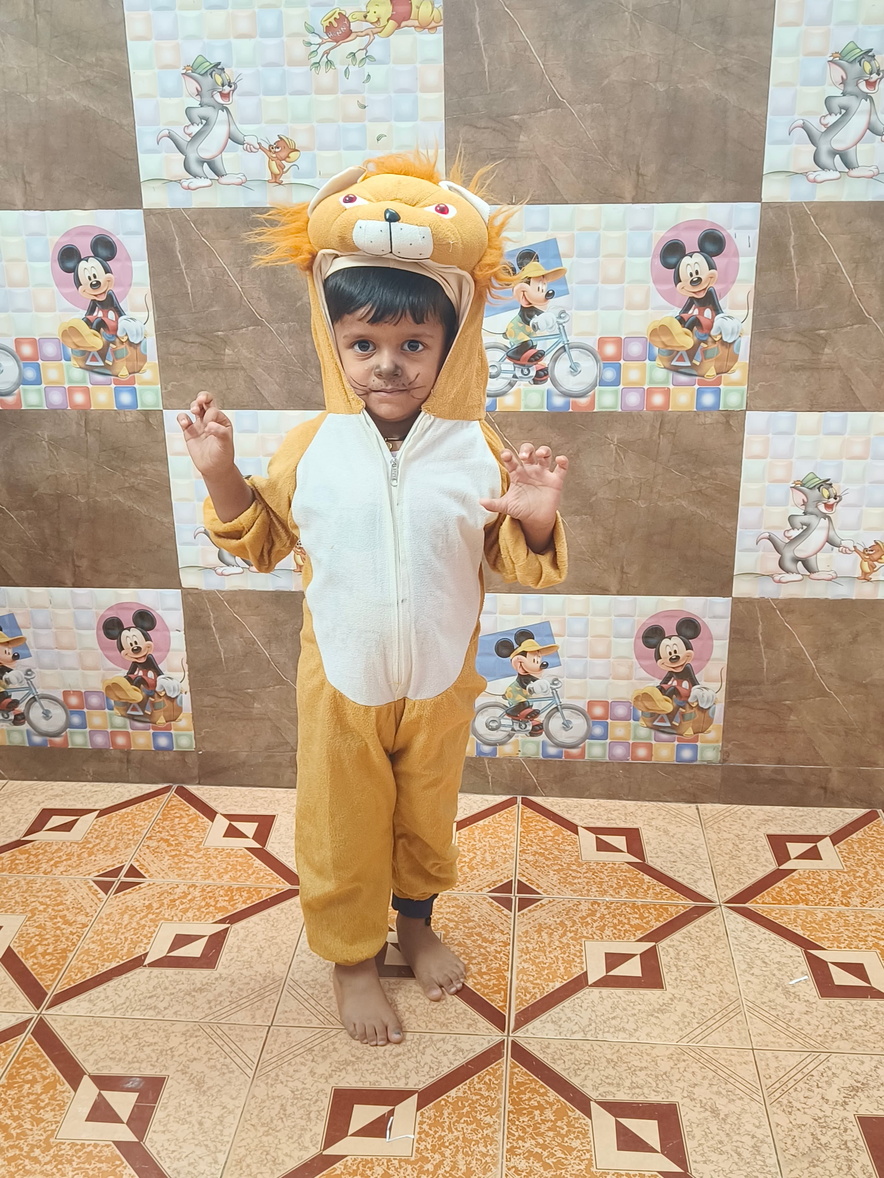 Boy in golden lion costume with mane hood and whisker face paint on Animal Day